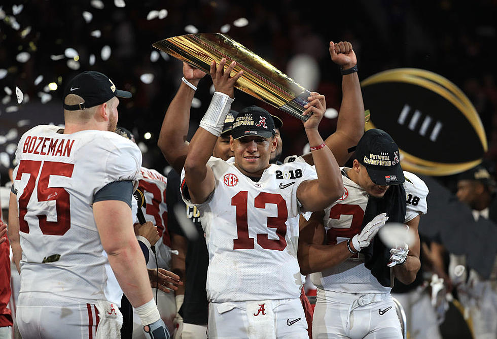 Tua Tagovailoa holds National Champioship trophy after throwing a game winning 41 yard touchdown pass